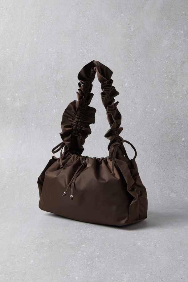 Fev_Ruffle bag_large(브라운) 숄더백은 부드러운 합성가죽 소재에 러플과 리본 장식으로 여성스러운 포인트를 더한 가방입니다. 넉넉한 수납공간과 가벼운 무게로 일상 속에서 편안하게 사용하기 좋습니다. 버킷 형태에 조임 끈으로 내용물을 안전하게 보관하며, 크로스백과 토트백으로 활용 가능한 2way 스타일 입니다. D링 장식으로 다양한 연출이 가능하며, 캐주얼 및 미니멀 스타일 모두 잘 어울립니다. 브라운 컬러의 무지 디자인으로 어떤 옷에도 쉽게 매치할 수 있습니다.
