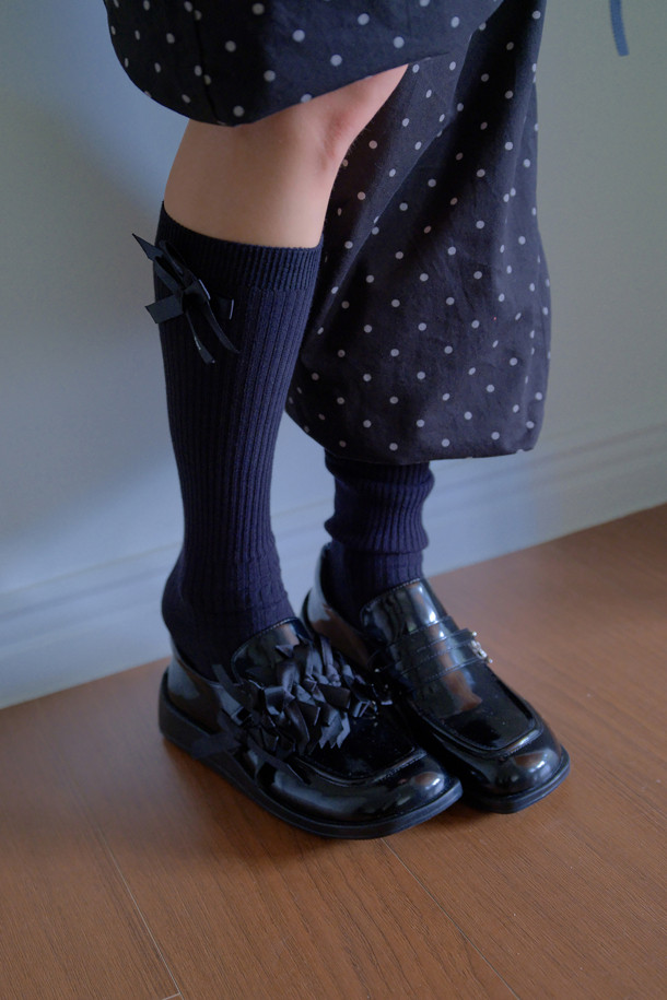 Fev 리본 무릎 양말(블랙)은 Fev 시그니처 디자인으로, 무릎 아래까지 오는 니삭스입니다. 부드러운 니트 소재로 제작되어 봄, 가을, 겨울 계절에 착용하기 좋으며, 신축성이 있어 편안한 착용감을 제공합니다. 양말 옆면에는 리본 디테일이 포인트로 들어가 있어, 베이직하면서도 걸리시한 스타일을 연출합니다. 데이트룩, 겨울 데일리룩, 모임룩 등 다양한 TPO에 클래식, 미니멀, 걸리시한 스타일로 매치하기 좋습니다.
