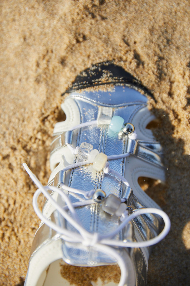 Fev 샌들(실버)는 여성용 샌들로, 데일리룩과 휴양지룩에 모두 잘 어울립니다. 소가죽, 매시, 나일론, 네오프렌 소재를 사용하여 편안함과 스타일을 동시에 잡았습니다. 실버 컬러에 벨크로 여밈으로 편의성을 더했으며, 비즈 장식, 측면 및 발등 컷아웃 디테일이 돋보입니다. 신끈 탈착 및 사이즈 조절 기능, 그리고 통기성이 뛰어나 봄, 여름 시즌에 유행을 타지 않고 오랫동안 착용할 수 있는 아이템입니다. 페미닌, 유니크, 아웃도어 스타일을 모두 아우르는 이 샌들을 여행지에서 미니멀하고 리조트룩으로 연출해 보세요.
