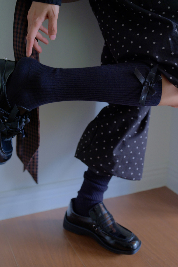 Fev 리본 무릎 양말(블랙)은 Fev 시그니처 디자인으로, 무릎 아래까지 오는 니삭스입니다. 부드러운 니트 소재로 제작되어 봄, 가을, 겨울 계절에 착용하기 좋으며, 신축성이 있어 편안한 착용감을 제공합니다. 양말 옆면에는 리본 디테일이 포인트로 들어가 있어, 베이직하면서도 걸리시한 스타일을 연출합니다. 데이트룩, 겨울 데일리룩, 모임룩 등 다양한 TPO에 클래식, 미니멀, 걸리시한 스타일로 매치하기 좋습니다.
