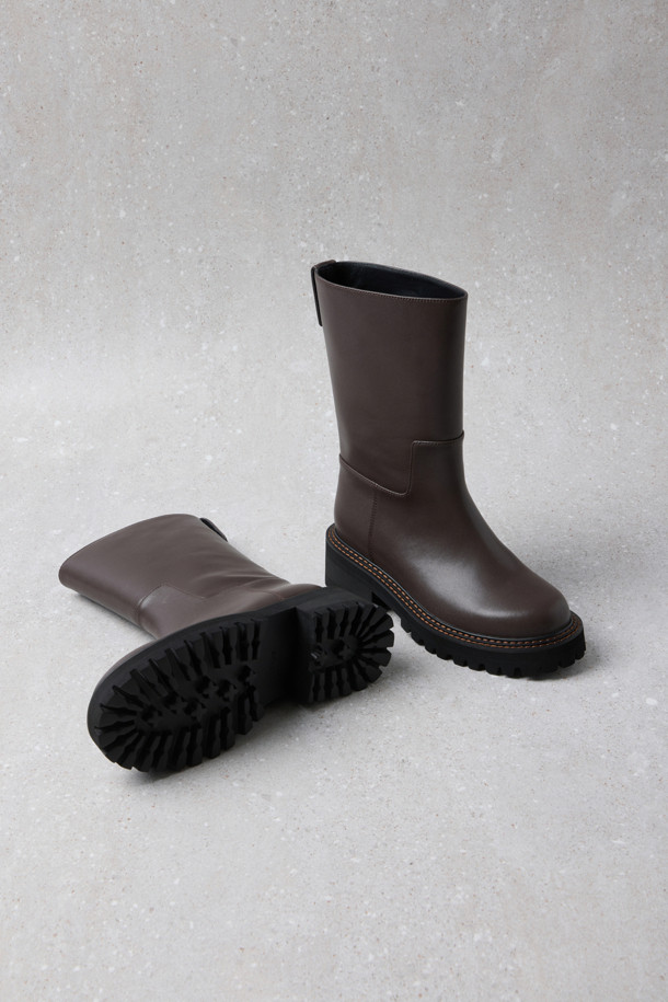 Fev_Young muze 부츠(브라운)는 여성들을 위한 미들 기장의 부츠입니다. 라운드 앞코와 통굽 디자인, 그리고 무지 패턴으로 미니멀하고 클래식한 분위기를 연출합니다. 합성가죽 소재에 볼드한 아웃솔과 러기드 아웃솔 디자인, FEV 심볼 적용으로 포인트를 더했습니다. 출근룩과 모임룩 모두에 어울리며, 가을과 겨울 시즌에 따뜻하고 스타일리시하게 착용할 수 있습니다. 
