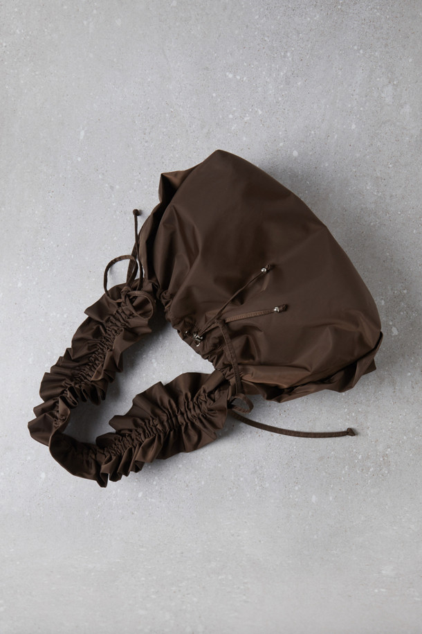 Fev_Ruffle bag_large(브라운) 숄더백은 부드러운 합성가죽 소재에 러플과 리본 장식으로 여성스러운 포인트를 더한 가방입니다. 넉넉한 수납공간과 가벼운 무게로 일상 속에서 편안하게 사용하기 좋습니다. 버킷 형태에 조임 끈으로 내용물을 안전하게 보관하며, 크로스백과 토트백으로 활용 가능한 2way 스타일 입니다. D링 장식으로 다양한 연출이 가능하며, 캐주얼 및 미니멀 스타일 모두 잘 어울립니다. 브라운 컬러의 무지 디자인으로 어떤 옷에도 쉽게 매치할 수 있습니다.
