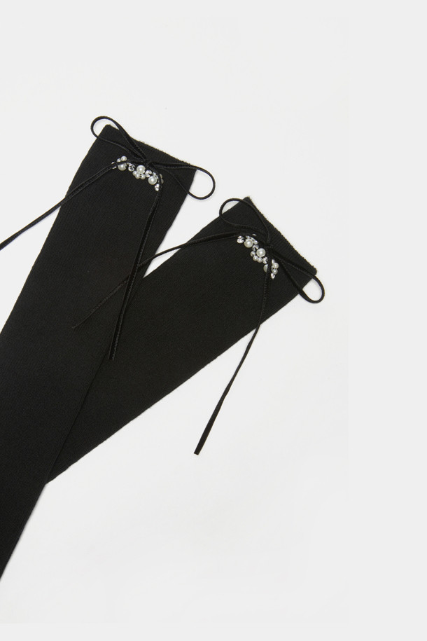 IHM 리본 니삭스(블랙)는 우아함과 화려함을 더하는 여성용 양말입니다. 블랙 색상에 무지 디자인으로 어떤 스타일에도 잘 어울리며, 부드러운 촉감으로 편안하게 착용할 수 있습니다. 무릎까지 오는 길이의 니삭스는 벨벳 리본, 진주 또는 크리스털 디테일 장식으로 포인트를 주어 로맨틱하고 클래식한 분위기를 연출합니다. 데이트룩이나 모임룩에 적합하며, 사계절 내내 착용 가능합니다. 
