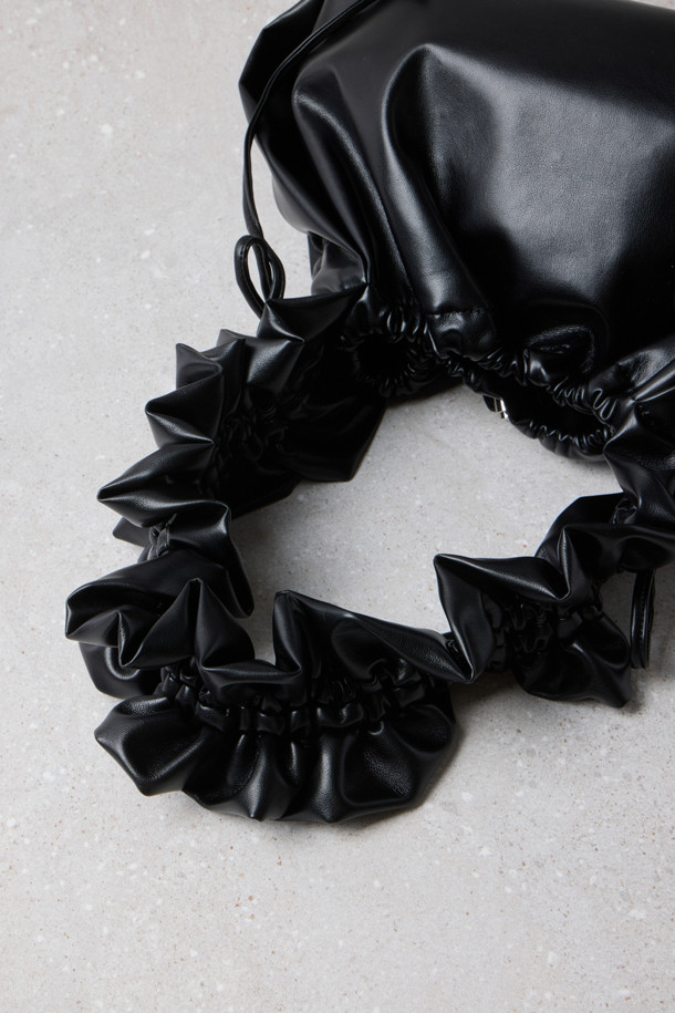 Fev 러플 백 라지(블랙)는 여성스러운 러플 디테일이 돋보이는 숄더백입니다. 부드러운 합성가죽 소재에 블랙 컬러로 제작되어 미니멀하고 시크한 스타일을 연출하며, 데이트룩, 쇼핑룩, 모임룩 등 다양한 TPO에 활용하기 좋습니다. 넉넉한 수납공간과 드로스트링 잠금 방식으로 실용성을 더했으며, 러플 길이 조절, 크로스백/숄더백/토트백 변형, 측면 D링 장착 등 다채로운 기능으로 활용도를 높였습니다. 가볍고 편안한 착용감으로 데일리 백으로 손색없으며, 라지 사이즈로 넉넉한 수납력을 제공합니다.
