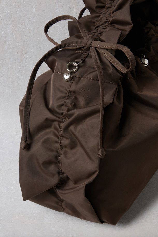 Fev_Ruffle bag_large(브라운) 숄더백은 부드러운 합성가죽 소재에 러플과 리본 장식으로 여성스러운 포인트를 더한 가방입니다. 넉넉한 수납공간과 가벼운 무게로 일상 속에서 편안하게 사용하기 좋습니다. 버킷 형태에 조임 끈으로 내용물을 안전하게 보관하며, 크로스백과 토트백으로 활용 가능한 2way 스타일 입니다. D링 장식으로 다양한 연출이 가능하며, 캐주얼 및 미니멀 스타일 모두 잘 어울립니다. 브라운 컬러의 무지 디자인으로 어떤 옷에도 쉽게 매치할 수 있습니다.
