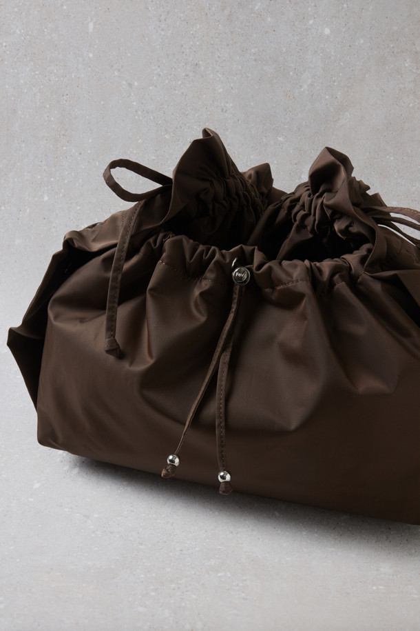 Fev_Ruffle bag_large(브라운) 숄더백은 부드러운 합성가죽 소재에 러플과 리본 장식으로 여성스러운 포인트를 더한 가방입니다. 넉넉한 수납공간과 가벼운 무게로 일상 속에서 편안하게 사용하기 좋습니다. 버킷 형태에 조임 끈으로 내용물을 안전하게 보관하며, 크로스백과 토트백으로 활용 가능한 2way 스타일 입니다. D링 장식으로 다양한 연출이 가능하며, 캐주얼 및 미니멀 스타일 모두 잘 어울립니다. 브라운 컬러의 무지 디자인으로 어떤 옷에도 쉽게 매치할 수 있습니다.
