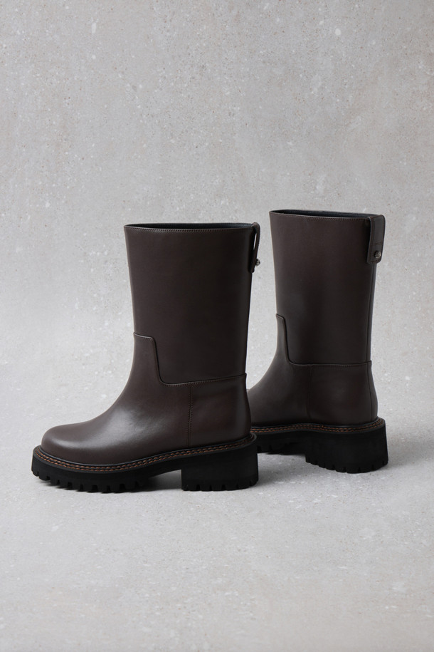 Fev_Young muze 부츠(브라운)는 여성들을 위한 미들 기장의 부츠입니다. 라운드 앞코와 통굽 디자인, 그리고 무지 패턴으로 미니멀하고 클래식한 분위기를 연출합니다. 합성가죽 소재에 볼드한 아웃솔과 러기드 아웃솔 디자인, FEV 심볼 적용으로 포인트를 더했습니다. 출근룩과 모임룩 모두에 어울리며, 가을과 겨울 시즌에 따뜻하고 스타일리시하게 착용할 수 있습니다. 
