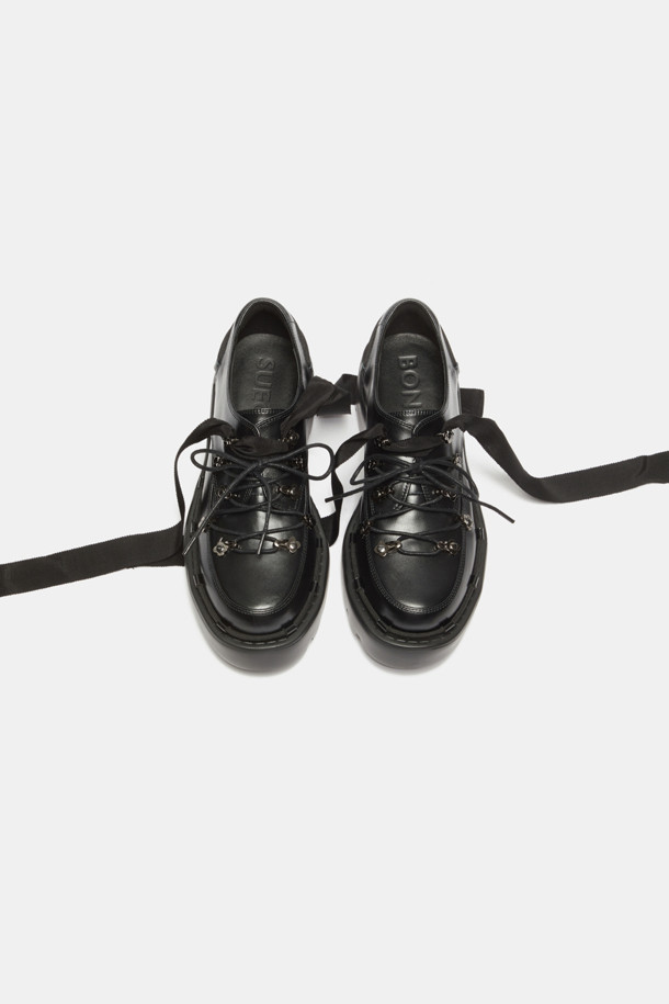 **Shoe lace 로퍼(black)**

소가죽 소재의 블랙 컬러 Shoe lace 로퍼입니다. 일상에서 편안하게 착용하기 좋은 플랫 굽 디자인으로, 캐주얼하면서도 여성스러운 분위기를 연출합니다. 리본 신끈과 고리 장식, 청키한 디자인이 돋보이며, 출근룩이나 모임룩에 미니멀한 스타일로 코디하기 좋습니다.
