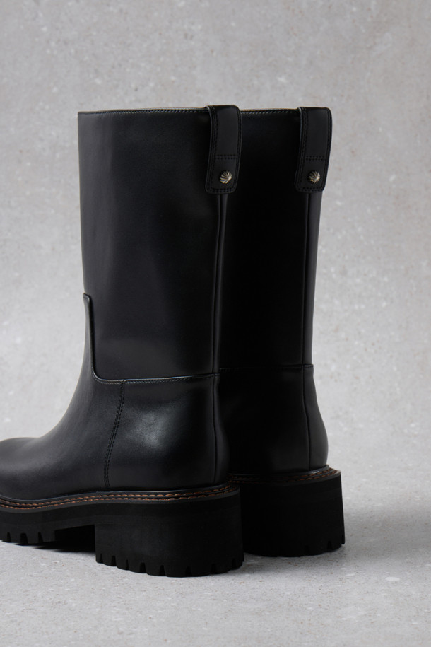 Fev_Young muze 부츠(블랙)는 미니멀한 디자인과 시크한 스타일을 추구하는 여성 고객을 위한 미디 부츠입니다. 소가죽 소재로 제작되어 고급스러운 질감을 자랑하며, 사계절 내내 다양한 룩에 활용할 수 있습니다. 볼드한 아웃솔과 러기드 아웃솔의 조합은 세련된 멋을 더하고, 불꽃 참 장식으로 포인트를 주었습니다. 미끄럼 방지 기능이 있어 안전하게 착용 가능하며, 출근룩에 완벽하게 어울립니다.
