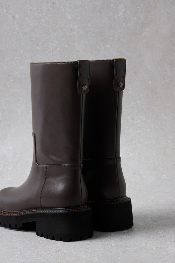 Fev_Young muze 부츠(브라운)는 여성들을 위한 미들 기장의 부츠입니다. 라운드 앞코와 통굽 디자인, 그리고 무지 패턴으로 미니멀하고 클래식한 분위기를 연출합니다. 합성가죽 소재에 볼드한 아웃솔과 러기드 아웃솔 디자인, FEV 심볼 적용으로 포인트를 더했습니다. 출근룩과 모임룩 모두에 어울리며, 가을과 겨울 시즌에 따뜻하고 스타일리시하게 착용할 수 있습니다. 
