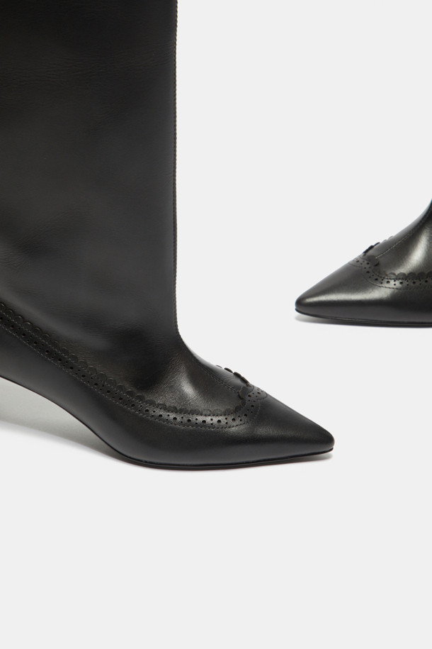 세련된 스타일을 완성하는 브로그 디테일 롱 부츠(블랙)입니다. 부드러운 소가죽 소재로 제작되어 편안한 착화감을 선사하며, 슬림한 실루엣이 다리 라인을 더욱 돋보이게 합니다. 포인티드 앞코와 미들힐 굽은 클래식하면서도 우아한 무드를 연출합니다. 가을, 겨울 시즌 오피스룩, 모임룩, 데이트룩에 모두 잘 어울리며, 다양한 스타일을 소화할 수 있는 매력적인 아이템입니다. 플라워 패턴이 은은하게 더해져 세련된 포인트를 더합니다.
