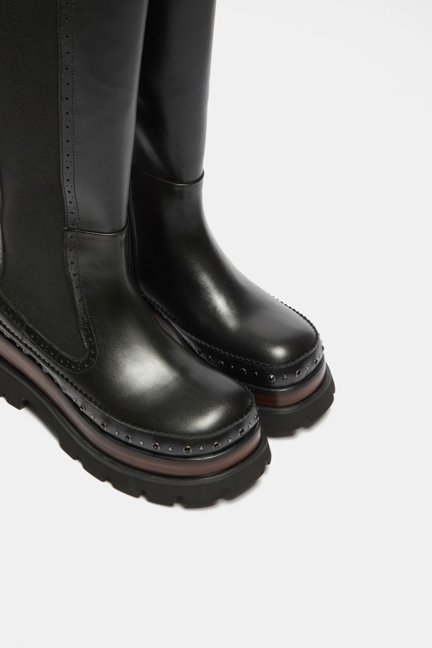 세련된 스타일을 완성하는 Stud long boots(스터드 롱 부츠, 블랙)입니다. 부드러운 소가죽 소재에 라운드 앞코 디자인으로 편안함을 더했으며, 굽 높이 6cm의 통굽으로 안정적인 착화감을 선사합니다. 사이드 엘라스틱 밴딩과 뒷라인 풀탭으로 신고 벗기 용이하며, 스터드 장식과 스티치 라인, 이중 몰드창과 몰드솔이 디자인의 완성도를 높입니다. 출근룩, 모임룩 등 다양한 TPO에 클래식, 캐주얼, 미니멀 스타일을 연출하여 세련된 분위기를 더해보세요.
