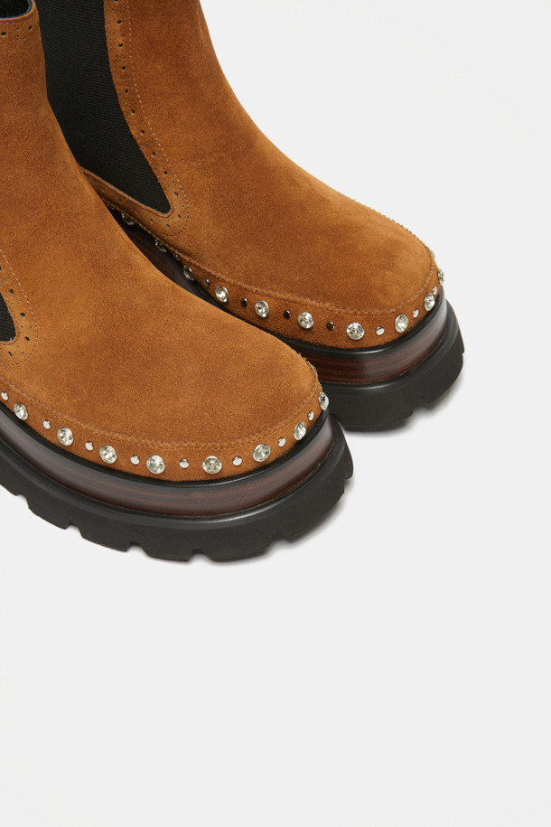 세련된 무드를 연출하는 스터드 앵클 부츠(브라운)입니다. 부드러운 소가죽 소재로 제작되어 고급스러운 질감을 자랑하며, 측면 밴딩 디테일이 편안한 착화감을 선사합니다. 클래식한 첼시부츠 실루엣에 스터드와 보석 장식이 더해져 유니크한 포인트를 더합니다. 로우힐 디자인으로 활동성을 높였으며, 출근룩과 모임룩 등 다양한 TPO에 활용 가능합니다. 미니멀, 시크, 클래식 스타일을 즐겨 입는 여성분들께 추천합니다.
