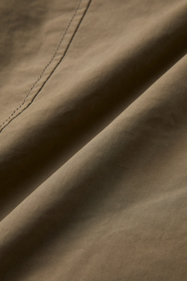 겨울철 일상과 출근룩, 여행룩에 모두 잘 어울리는 구스 코트입니다. 카키와 브라운 두 가지 색상으로 출시되어 미니멀하고 베이직한 스타일을 연출합니다. 롱 기장에 세미 오버핏으로 편안한 착용감을 선사하며, 버튼 여밈 방식으로 간편하게 입고 벗을 수 있습니다. 나일론과 폴리에스테르 혼방 소재로 제작되어 두꺼운 두께감과 부드러운 촉감을 자랑하며, 드롭숄더 디자인과 퀼팅 안감, 생활 방수 및 방풍 기능을 갖춰 보온성을 높였습니다. 
