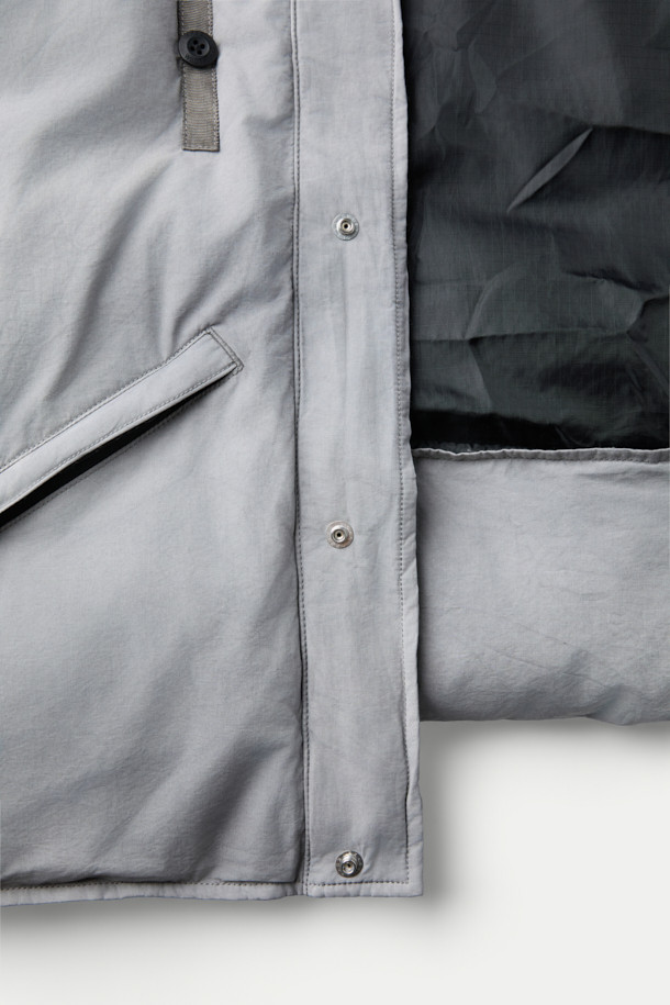 INNAT(인낫) x WILD THINGS(와일드 띵스) 가먼트 다이드 마칼루 다운은 일상과 아웃도어 활동 모두에 적합한 남녀 공용 다운점퍼입니다. 톤 다운된 그레이 컬러와 캐주얼, 아웃도어 스타일을 결합하여 다양한 룩에 활용하기 좋습니다. 면, 나일론 혼방 소재로 제작되었으며, 덕다운 80%, 페더 20% 충전재로 뛰어난 보온성을 제공합니다. 2-WAY 후드, WILD CAT 로고, 게임 포켓 등의 디테일과 피그먼트 염색 가공으로 빈티지한 텍스처를 더했습니다. 스냅버튼 밑단 조절 기능으로 사이즈 조절이 가능하며, 겨울철 여행, 캠핑, 등산 시 따뜻하고 스타일리시하게 연출할 수 있습니다.
