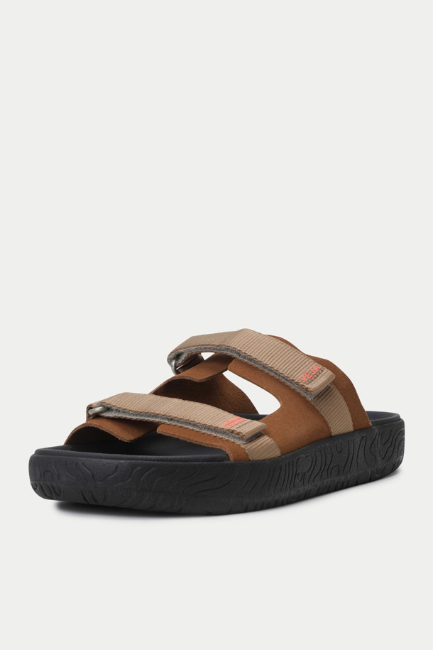 HOMECORE X VEJA 샌들은 브라운과 블랙 두 가지 색상으로 출시된 남성용 샌들입니다. 오픈토 디자인과 스트랩 여밈으로 편안하면서도 세련된 스타일을 연출합니다. 스웨이드, 고무, 가죽, 폴리에스테르 등 지속 가능한 소재를 사용하여 제작되었으며, 가죽 안감으로 부드러운 착용감을 선사합니다. 플랫 굽과 심플한 디자인은 휴가룩, 리조트룩, 여행룩 등 다양한 TPO에 활용하기 좋습니다. 발의 형태를 자연스럽게 따라가는 디자인과 스트랩으로 사이즈 조절이 가능하며, 미니멀, 캐주얼, 리조트 스타일을 즐기는 남성에게 완벽한 선택입니다.
