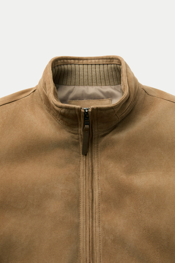 베이지 컬러의 스웨이드 다운 점퍼입니다. 간절기와 초겨울에 적합하며, 클래식하고 미니멀한 스타일을 연출합니다. 부드러운 스웨이드 소재와 두꺼운 두께감으로 포근함을 더하고, 구스다운 충전재를 사용하여 보온성을 높였습니다. 스탠드넥 구조와 니트 시보리 디테일이 돋보이며, 안감과 다운백 분리 설계로 편안함을 제공합니다. 투웨이 지퍼와 긴 소매 기장으로 출근룩에 활용하기 좋습니다.
