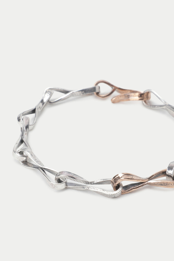 노스 웍스 E-046은 925 실버와 로즈 골드 컬러의 조화가 돋보이는 브레이슬릿입니다. 트위스트 체인 디자인과 수작업으로 제작된 섬세함이 돋보이며, 빈티지 코인 소재를 사용하여 클래식하면서도 미니멀한 스타일을 연출합니다. 데이트룩이나 모임룩에 포인트 아이템으로 활용하기 좋으며, 시크한 매력을 더해줍니다. 일상에서도 세련된 스타일을 완성할 수 있는 아이템입니다.
