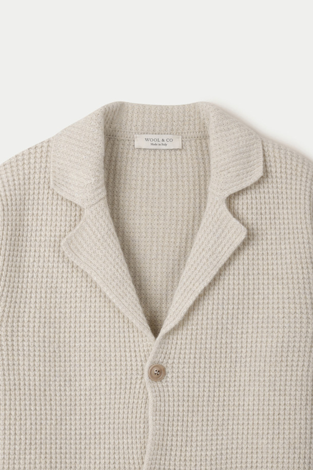 WOOL & CO (울 앤 코) 다잉 와플 가디건은 가을, 겨울 시즌에 어울리는 남녀 공용 가디건입니다. 부드러운 촉감의 울 소재로 제작되었으며, 두꺼운 두께감으로 따뜻하게 착용할 수 있습니다. 클래식한 무드의 아이보리 컬러, 레귤러핏, 긴 소매 기장, 와플 패턴이 특징입니다. 데이트룩, 모임룩, 출근룩 등 다양한 TPO에 활용 가능하며, 클래식, 미니멀, 캐주얼 스타일을 연출하기 좋습니다. 테일러드 코트 타입에 버튼 여밈 방식, 포켓 디테일이 더해져 실용성을 높였습니다.
