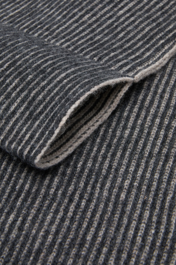 그레이와 블랙 투톤 배색의 스트라이프 슬릿 니트 머플러입니다. 울, 캐시미어, 나일론 혼방 소재로 제작되어 부드러운 촉감과 뛰어난 보온성을 자랑합니다. 슬릿 디테일이 돋보여 착용이 편리하며, 베이직하고 클래식한 디자인으로 출근룩, 모임룩 등 다양한 TPO에 활용 가능합니다. 가을, 겨울 시즌에 스타일리시함과 따뜻함을 동시에 선사하는 머플러입니다. 미니멀, 캐주얼 스타일에도 잘 어울립니다.
