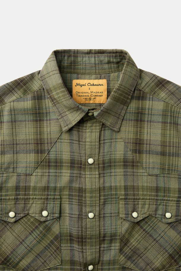 NIGEL CABOURN (나이젤 카본) X ORIGINAL MADRAS (오리지널 마드라스) 웨스턴 셔츠는 웨스턴 스타일을 기반으로 한 상의입니다. 슬림핏으로 디자인되었으며, 화이트 컬러의 면 소재로 제작되었습니다. 패치 포켓과 비조 디테일이 특징이며, 클래식, 미니멀, 캐주얼 스타일을 연출하기 좋습니다. 숏 기장의 웨스턴 셔츠로 다양한 하의와 매치하여 개성 있는 스타일을 완성할 수 있습니다.
