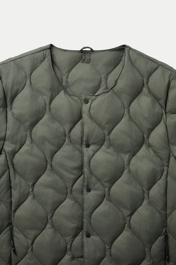 F/CE X TAION(에프씨이 X 테이온) 패커블 이너 덕 다운 재킷은 겨울철 일상룩과 여행, 캠핑룩에 적합한 남녀 공용 아우터입니다. 미니멀하고 캐주얼한 스타일을 연출하며, 퀄팅 패턴과 크롭 기장이 특징입니다. 800 필파워 화이트 덕다운 충전재와 발수 처리, 생활 방수 기능을 갖춰 보온성을 높였습니다. 
버튼 여밈 방식이며, 부드러운 촉감의 나일론 소재와 긴 소매 기장으로 제작되었습니다. 보관용 파우치가 포함되어 휴대 및 보관이 용이합니다.
카키와 올리브 두 가지 색상으로 출시되었습니다.
