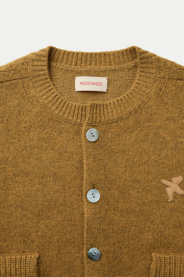 MIDTHINGS(미드띵스) 버드 패치 가디건은 가을, 겨울 시즌에 어울리는 여성 상의 니트/스웨터입니다. 머스타드와 브라운 두 가지 색상으로 만나볼 수 있으며, 캐주얼하고 베이직한 스타일을 연출합니다. 울과 코튼 혼방 소재로 제작되어 따뜻하고 포근하며, 루즈핏과 크롭 기장으로 편안한 착용감을 선사합니다. 엄지 홀 디테일과 볼륨감 있는 소매, 천연 조개 버튼, 패치 디자인이 돋보이며, 데이트룩, 모임룩, 캐주얼, 클래식, 미니멀 스타일 모두 소화 가능합니다.
