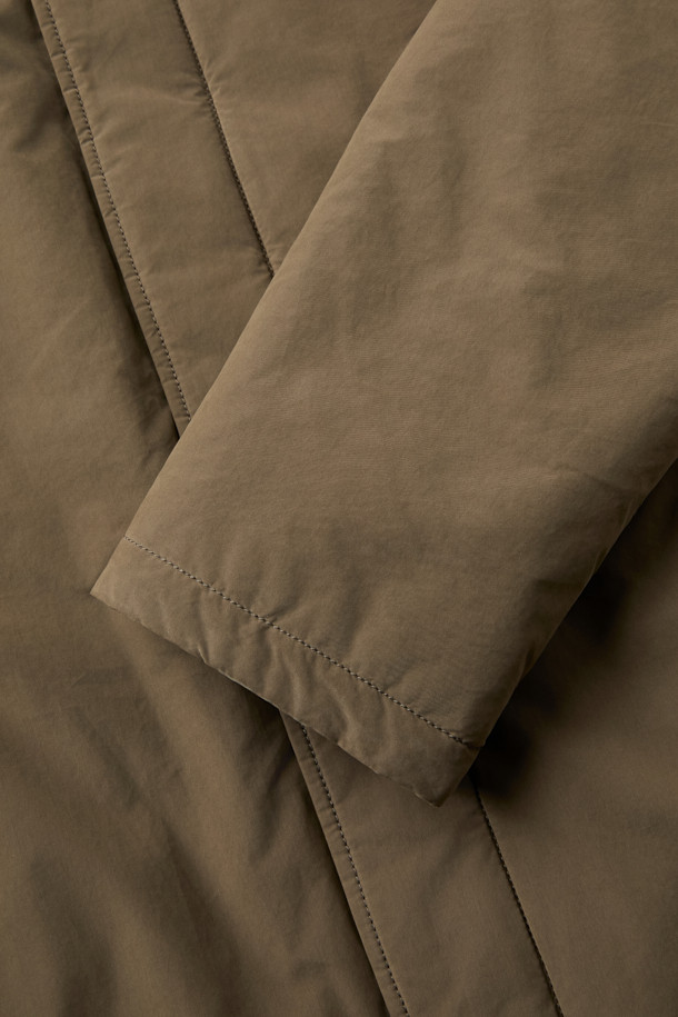 겨울철 일상과 출근룩, 여행룩에 모두 잘 어울리는 구스 코트입니다. 카키와 브라운 두 가지 색상으로 출시되어 미니멀하고 베이직한 스타일을 연출합니다. 롱 기장에 세미 오버핏으로 편안한 착용감을 선사하며, 버튼 여밈 방식으로 간편하게 입고 벗을 수 있습니다. 나일론과 폴리에스테르 혼방 소재로 제작되어 두꺼운 두께감과 부드러운 촉감을 자랑하며, 드롭숄더 디자인과 퀼팅 안감, 생활 방수 및 방풍 기능을 갖춰 보온성을 높였습니다. 
