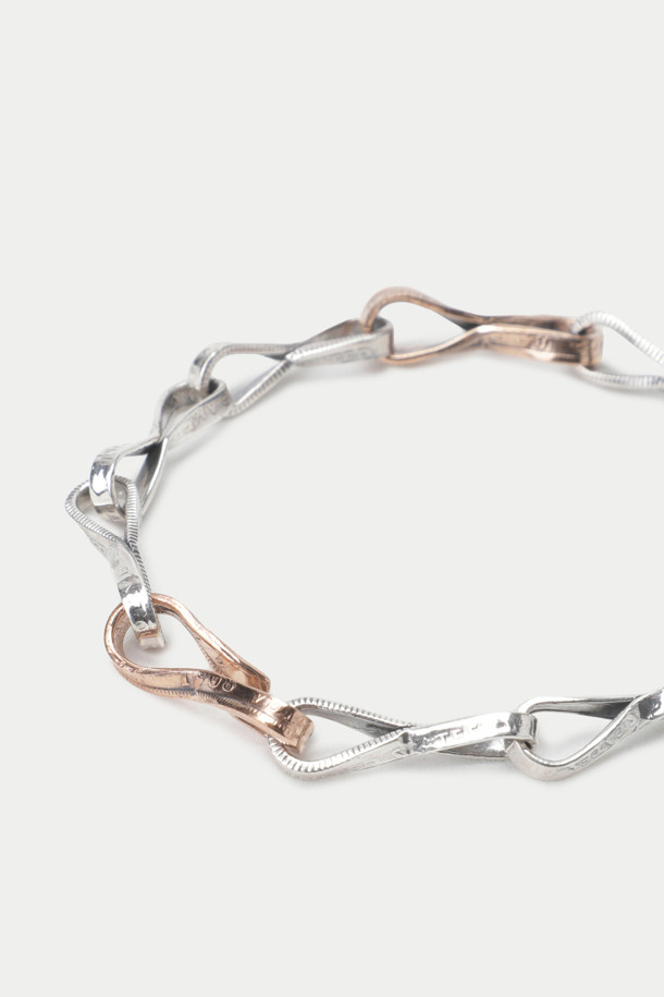 노스 웍스 E-046은 925 실버와 로즈 골드 컬러의 조화가 돋보이는 브레이슬릿입니다. 트위스트 체인 디자인과 수작업으로 제작된 섬세함이 돋보이며, 빈티지 코인 소재를 사용하여 클래식하면서도 미니멀한 스타일을 연출합니다. 데이트룩이나 모임룩에 포인트 아이템으로 활용하기 좋으며, 시크한 매력을 더해줍니다. 일상에서도 세련된 스타일을 완성할 수 있는 아이템입니다.
