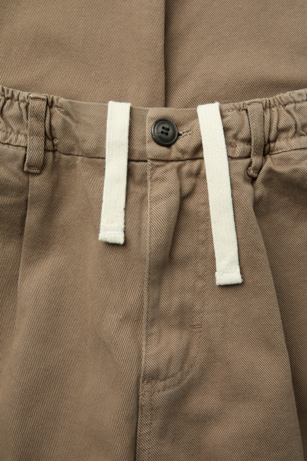 FIVER(파이버) 트윌 배기 팬츠는 캐주얼, 미니멀, 클래식 스타일을 아우르는 바지입니다. 면 소재로 제작되어 탄탄한 촉감을 자랑하며, 봄, 가을에 착용하기 좋습니다. 베이지, 카키 두 가지 색상으로 출시되어 일상 및 캐주얼 룩에 활용하기 좋으며, 출근룩으로도 손색없습니다. 루즈핏의 배기 디자인으로 편안함을 더하고, 원턱 디테일과 허리 스트링, 웨이스트 밴딩으로 활동성을 높였습니다. 힙 포켓과 사이드 포켓, 버튼/지퍼 여밈으로 실용성을 강조한 제품입니다.
