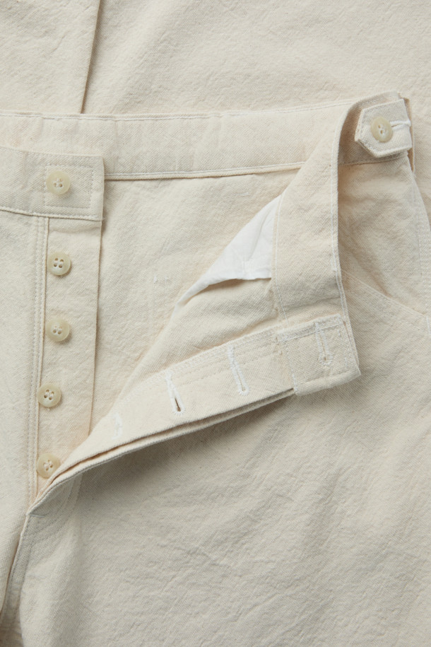 INNAT(인낫) 페인터 팬츠는 클래식, 캐주얼, 워크웨어 스타일을 아우르는 남성용 바지입니다. 아이보리, 베이지 두 가지 색상으로 출시되었으며, 봄, 여름, 가을 3계절 모두 착용 가능합니다. 10온스 경량의 부드러운 면 소재로 제작되어 편안한 착용감을 선사하며, 밴딩 처리로 활동성을 높였습니다. 빈티지 워싱과 트리플 니들 스티치 디테일, 버튼플라이 여밈, 오가닉 코튼 사용으로 내구성과 디자인 완성도를 높였습니다. 레귤러핏의 긴 기장으로 어떤 상의와도 자연스럽게 매치하여 멋스러운 룩을 연출할 수 있습니다.
