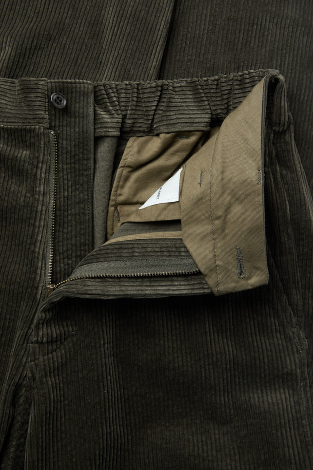 SAGE DE CRET(사지 드 크레) 코듀로이 페그탑 팬츠는 가을과 겨울에 어울리는 남성용 코듀로이 바지입니다. 빈티지하면서도 아방가르드한 스타일을 연출하며, 올리브 색상의 무지 디자인이 특징입니다. 7골 코듀로이 소재로 제작되어 부드러운 촉감을 선사하며, 하이라이즈 실루엣과 오버핏, 루즈핏으로 편안한 착용감을 제공합니다. 텀블 가공과 가먼트 워싱 처리로 자연스러운 멋을 더했으며, 뒷밴딩으로 활동성을 높였습니다. 겨울 데일리룩, 산책룩, 동네 마실룩 등 다양한 TPO에 클래식, 캐주얼, 워크웨어 스타일로 활용하기 좋습니다. 
