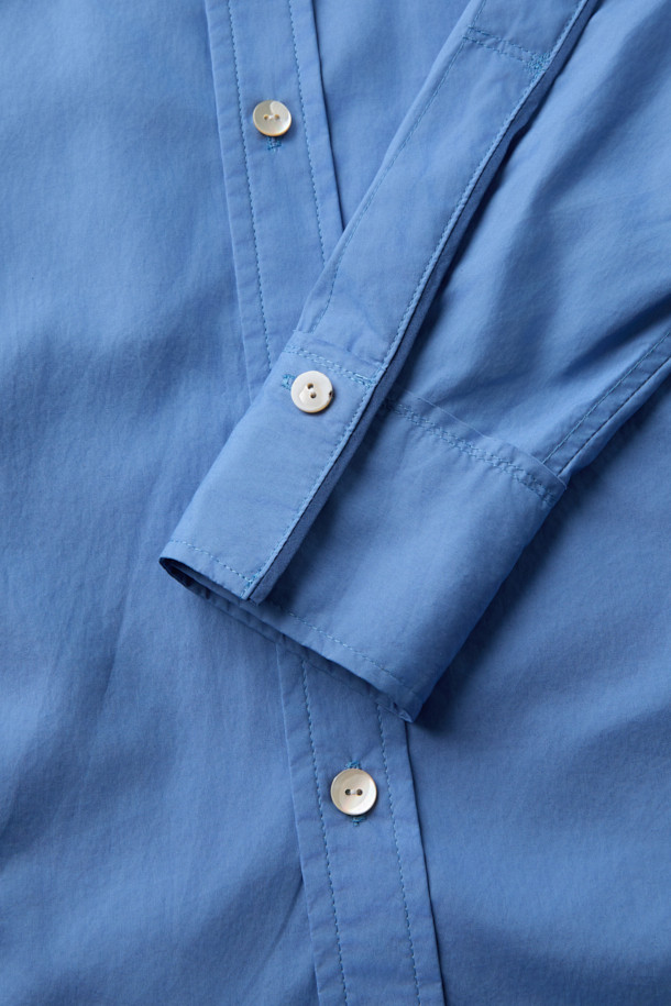 MIDTHINGS(미드띵스) 셔츠는 부드러운 촉감의 오가닉 코튼 소재로 제작되어 편안한 착용감을 선사합니다. 블루 컬러의 무지 디자인에, 반소매 크롭 기장으로 시원하고 미니멀한 스타일을 연출합니다. 루즈핏 실루엣과 초승달 모티브 포켓, 랜덤 스티치 디테일이 돋보이며, 데이트룩과 여행룩, 캐주얼 및 클래식 스타일 모두에 잘 어울립니다. 봄, 여름 시즌에 활용하기 좋은 얇은 두께의 셔츠입니다.
