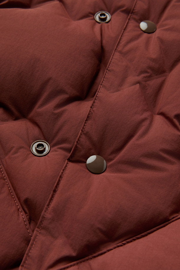 CMF 우븐 다운 베스트는 가을, 겨울철 일상 및 아웃도어 활동에 적합한 남녀 공용 베스트입니다. 브라운 컬러의 퀼팅 패턴과 크롭 기장으로 캐주얼, 스포티, 미니멀 스타일을 연출할 수 있습니다. CMF WOVEN 기술을 적용하여 다운팩 없이 X자 구조로 직조되었으며, 다운 90%, 페더 10% (700FP)의 안감과 다운 본딩 처리로 보온성을 높였습니다. 얇고 가벼운 나일론, 폴리우레탄 소재에 넉넉한 두께감과 부드러운 촉감, 사선 포켓 디자인이 특징입니다. 캠핑룩으로 활용하기 좋으며 스냅 여밈 방식으로 편안하게 착용할 수 있습니다.
