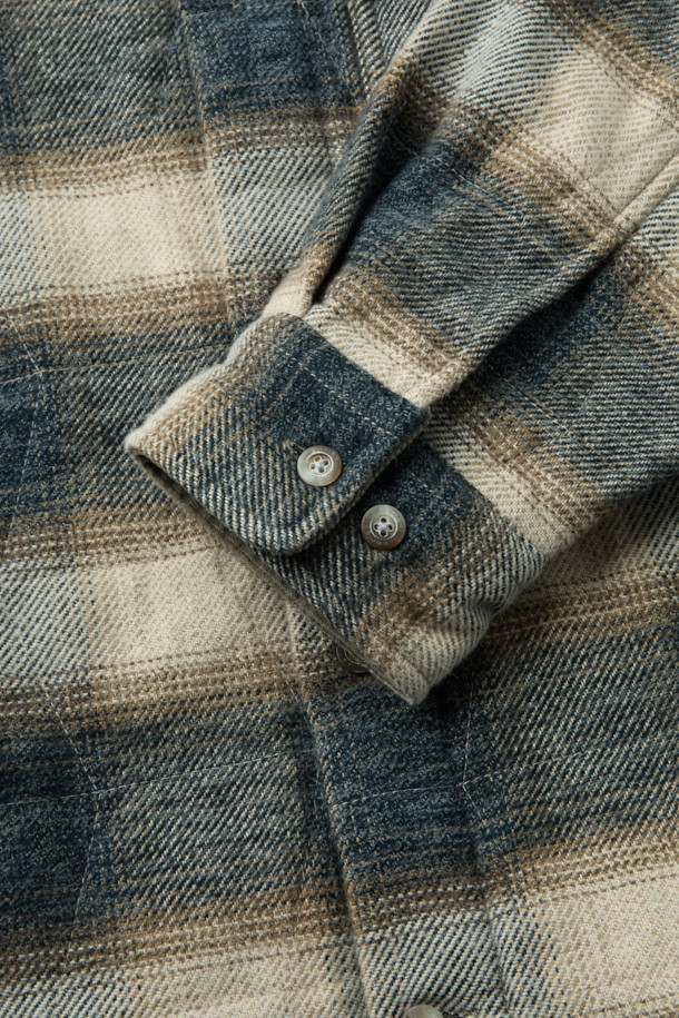 "체크 퀼팅 아우터 셔츠"는 빈티지 스타일의 코듀로이 소재 아우터 셔츠입니다. 부드러운 촉감과 적당한 두께감으로 간절기부터 초겨울까지 착용하기 좋으며, 3M 신슐레이트 충전재를 사용하여 뛰어난 보온성을 제공합니다. 네이비와 베이지 두 가지 컬러로 출시되었으며, 셔츠형 디자인에 퀼팅 디테일과 가슴 1개, 허리 2개의 포켓, 칼라 부분의 코듀로이 배색이 돋보입니다. 세미 오버핏으로 제작되어 편안하면서도 스타일리시하게 연출할 수 있으며, 스냅 버튼으로 간편하게 여밀 수 있습니다. 출근룩과 모임룩은 물론 클래식, 캐주얼, 미니멀 등 다양한 스타일 연출에 활용 가능한 아이템입니다.
