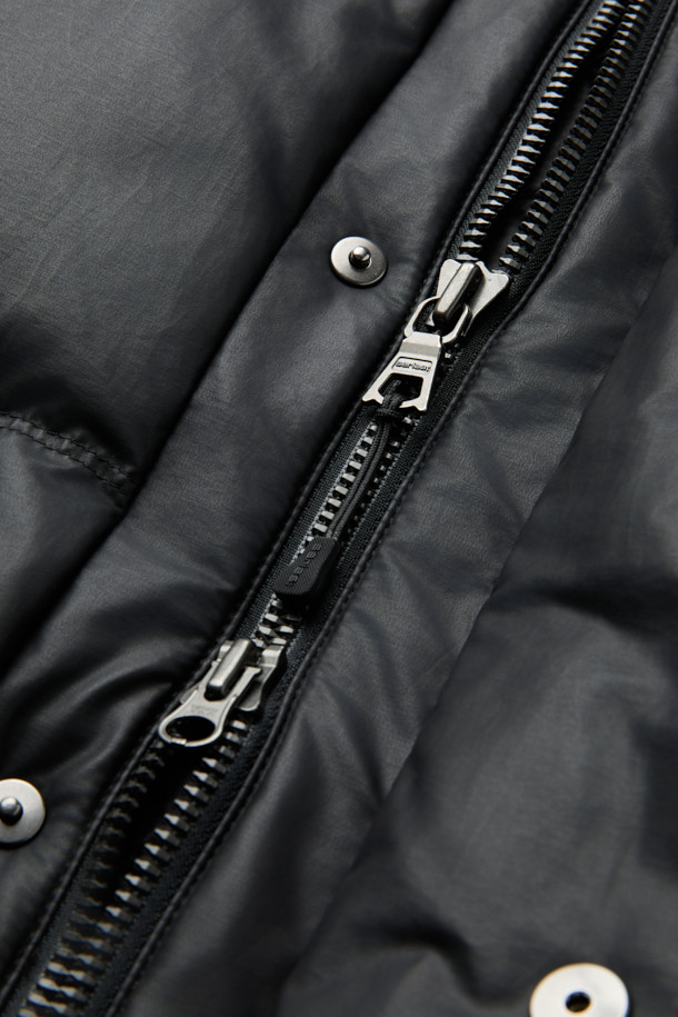 레더라이크 숏 패딩은 세련된 겨울 스타일을 완성하는 필수템입니다. 인조 가죽 소재와 퀼팅 디자인이 어우러져 캐주얼하면서도 모던한 분위기를 연출합니다. 덕다운 충전재와 방풍, 발수 기능으로 보온성을 높였으며, 경량 설계로 편안한 착용감을 제공합니다. 스탠드 넥과 니트립 소맷단, 사이드 포켓 디테일로 실용성을 더했으며, 출근룩과 여행룩 등 다양한 TPO에 활용 가능합니다. 블랙 컬러의 세미루즈핏으로 어떤 스타일에도 쉽게 매치하여 미니멀, 클래식 무드를 연출할 수 있습니다.
