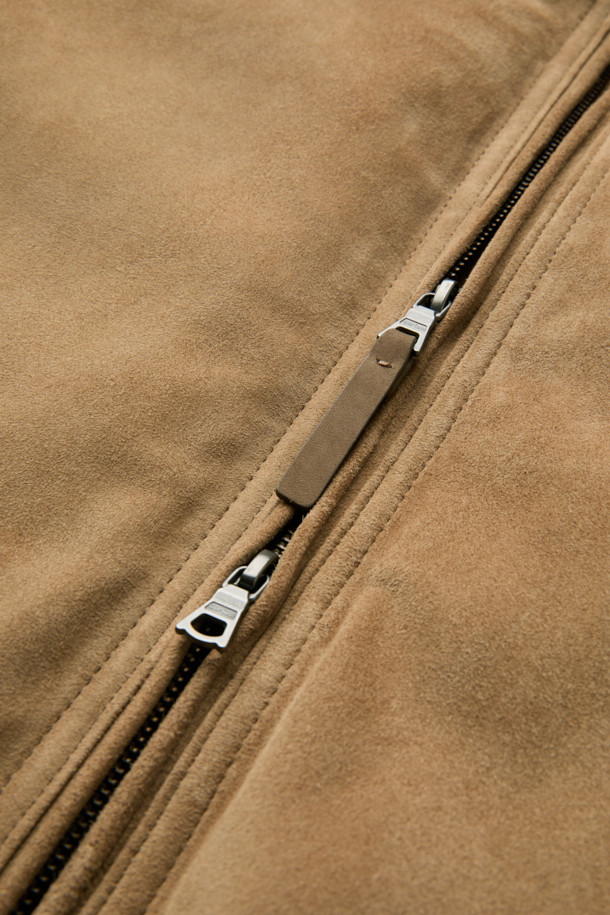 베이지 컬러의 스웨이드 다운 점퍼입니다. 간절기와 초겨울에 적합하며, 클래식하고 미니멀한 스타일을 연출합니다. 부드러운 스웨이드 소재와 두꺼운 두께감으로 포근함을 더하고, 구스다운 충전재를 사용하여 보온성을 높였습니다. 스탠드넥 구조와 니트 시보리 디테일이 돋보이며, 안감과 다운백 분리 설계로 편안함을 제공합니다. 투웨이 지퍼와 긴 소매 기장으로 출근룩에 활용하기 좋습니다.
