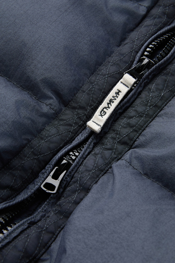 **HANKALEX(헝카렉스) 다이드 덕 다운**은 빈티지한 스타일의 네이비 컬러 덕 다운 아우터입니다. 겨울철 보온성을 책임지는 두꺼운 두께감과 루즈핏으로 편안한 착용감을 선사합니다. 발수 기능과 PU 필름 코팅으로 생활 방수가 가능하며, 가먼트 다잉 처리로 특유의 빈티지한 멋을 더했습니다. 소매 시보리 디테일과 전면 지퍼 포켓으로 실용성을 높였으며, 출근룩과 여행룩, 캐주얼, 미니멀, 클래식 스타일 모두 소화 가능한 활용도 높은 아이템입니다.
