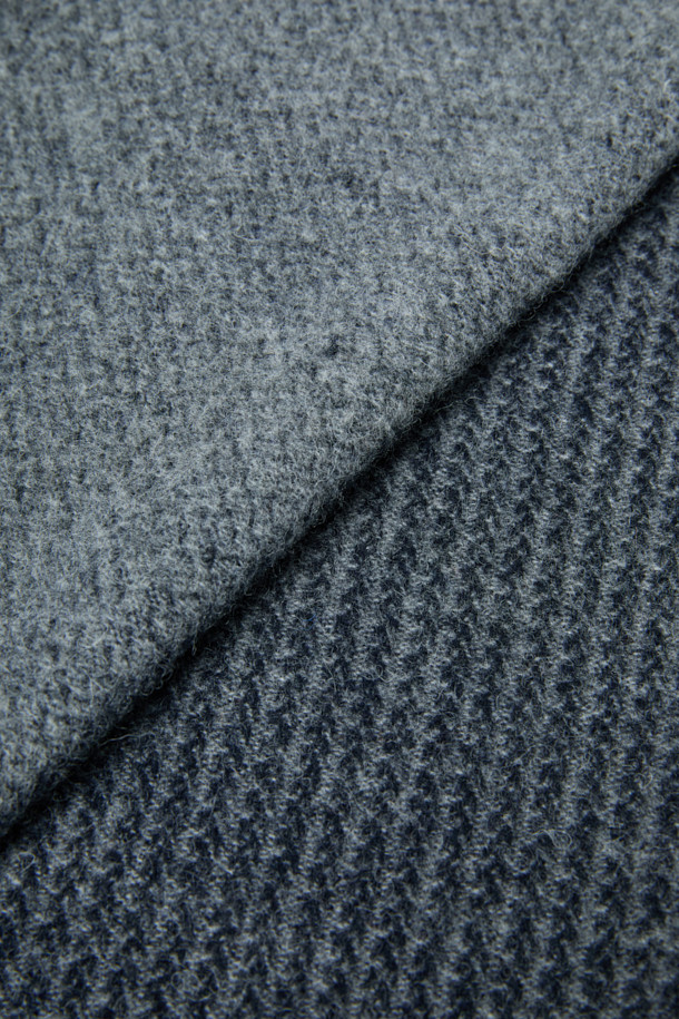 네이비 하운드투스 울 머플러는 가을, 겨울철 출근룩과 모임룩에 포인트를 더하는 클래식, 미니멀, 캐주얼 스타일의 머플러입니다. 부드러운 촉감의 울 100% 소재로 제작되었으며, 멜란지 네이비 컬러와 하운드투스 패턴의 조화가 세련된 분위기를 연출합니다. 섬세한 조직감의 짜임과 태슬 디테일은 고급스러움을 더하며, 어떤 룩에도 자연스럽게 어울립니다. 따뜻함과 스타일을 동시에 만족시키는 데일리 머플러입니다.
