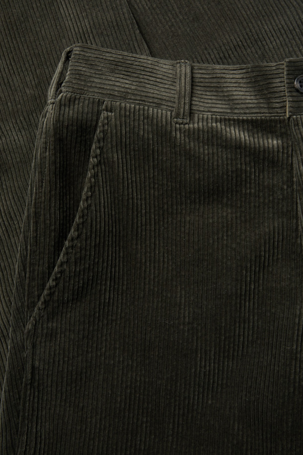 SAGE DE CRET(사지 드 크레) 코듀로이 페그탑 팬츠는 가을과 겨울에 어울리는 남성용 코듀로이 바지입니다. 빈티지하면서도 아방가르드한 스타일을 연출하며, 올리브 색상의 무지 디자인이 특징입니다. 7골 코듀로이 소재로 제작되어 부드러운 촉감을 선사하며, 하이라이즈 실루엣과 오버핏, 루즈핏으로 편안한 착용감을 제공합니다. 텀블 가공과 가먼트 워싱 처리로 자연스러운 멋을 더했으며, 뒷밴딩으로 활동성을 높였습니다. 겨울 데일리룩, 산책룩, 동네 마실룩 등 다양한 TPO에 클래식, 캐주얼, 워크웨어 스타일로 활용하기 좋습니다. 
