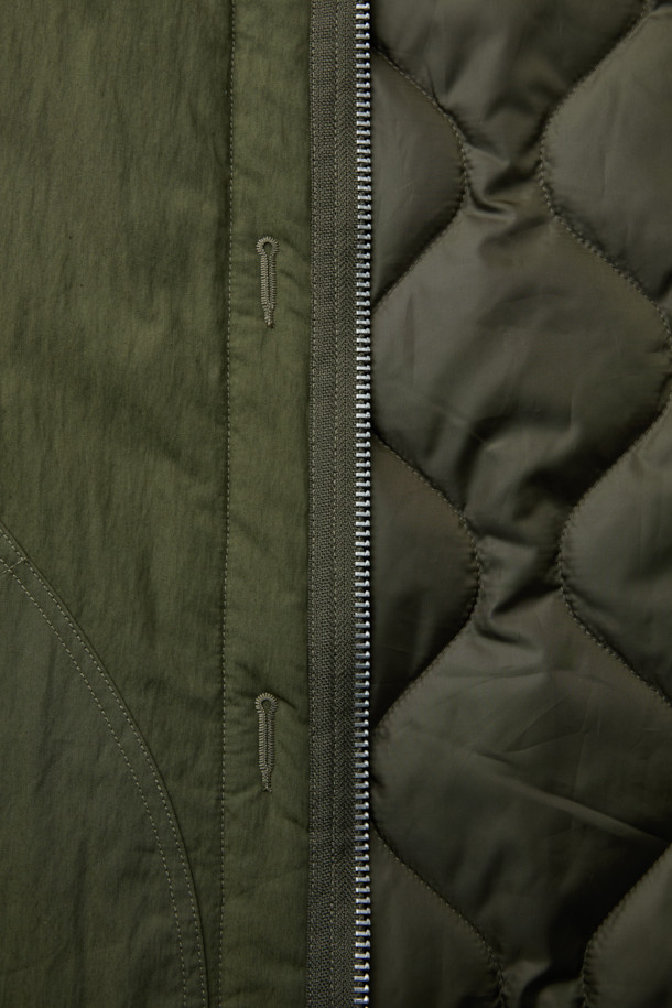 SAGE DE CRET (세이지 드 크레) 리버서블 라이너 타입 베스트는 가을, 겨울 시즌 남성 데일리룩, 산책룩, 여행룩에 적합한 아우터입니다. 올리브와 블랙 두 가지 색상으로 출시되었으며, 워크웨어, 미니멀, 클래식 스타일을 모두 아우르는 디자인입니다. 면과 나일론 혼방의 두꺼운 소재로 제작되어 부드러운 촉감과 누빔 안감이 특징이며, 발수 기능을 갖추었습니다. 리버서블 디자인으로 다양한 연출이 가능하며, 오버핏으로 편안하게 착용할 수 있습니다. 집업 여밈 방식에 크롭 기장으로 워크웨어 스타일 포켓, 싱글 웰트 포켓, 엘라스틱 밴드 디테일이 돋보입니다.
