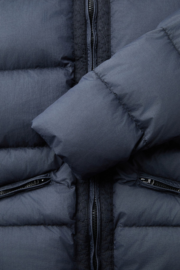 **HANKALEX(헝카렉스) 다이드 덕 다운**은 빈티지한 스타일의 네이비 컬러 덕 다운 아우터입니다. 겨울철 보온성을 책임지는 두꺼운 두께감과 루즈핏으로 편안한 착용감을 선사합니다. 발수 기능과 PU 필름 코팅으로 생활 방수가 가능하며, 가먼트 다잉 처리로 특유의 빈티지한 멋을 더했습니다. 소매 시보리 디테일과 전면 지퍼 포켓으로 실용성을 높였으며, 출근룩과 여행룩, 캐주얼, 미니멀, 클래식 스타일 모두 소화 가능한 활용도 높은 아이템입니다.
