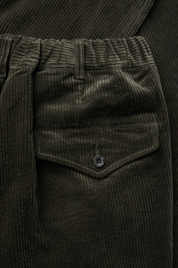 SAGE DE CRET(사지 드 크레) 코듀로이 페그탑 팬츠는 가을과 겨울에 어울리는 남성용 코듀로이 바지입니다. 빈티지하면서도 아방가르드한 스타일을 연출하며, 올리브 색상의 무지 디자인이 특징입니다. 7골 코듀로이 소재로 제작되어 부드러운 촉감을 선사하며, 하이라이즈 실루엣과 오버핏, 루즈핏으로 편안한 착용감을 제공합니다. 텀블 가공과 가먼트 워싱 처리로 자연스러운 멋을 더했으며, 뒷밴딩으로 활동성을 높였습니다. 겨울 데일리룩, 산책룩, 동네 마실룩 등 다양한 TPO에 클래식, 캐주얼, 워크웨어 스타일로 활용하기 좋습니다. 
