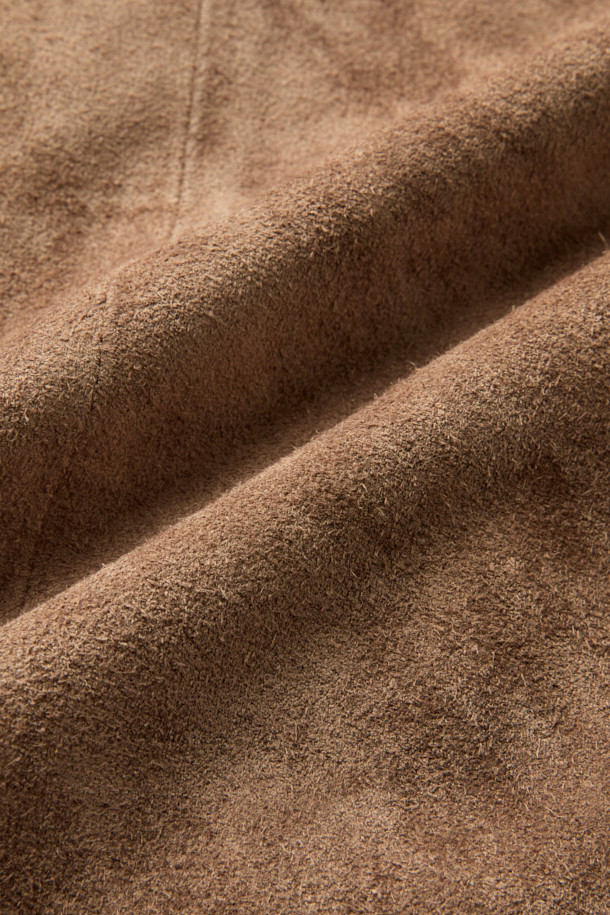 A LEATHER (레더) 집 후디는 부드러운 소가죽, 레이온, 면 혼방 소재로 제작된 남녀 공용 가죽 후드 집업입니다. 가을, 겨울 시즌에 어울리며, 캐주얼, 스트릿, 미니멀 스타일을 연출하기 좋습니다. 크롭 기장의 레귤러핏으로, 스웨트셔츠 봉제 기법과 소매 및 밑단 가죽 립 처리, 파워 네트 삽입을 통한 신축성 구현으로 활동성을 높였습니다. 넉넉한 두께감과 부드러운 촉감, 무지 디자인이 특징이며, 여행룩 또는 캠핑룩에 활용하기 좋습니다. 안감은 레이온/면 혼방으로 제작되어 편안한 착용감을 선사합니다.
