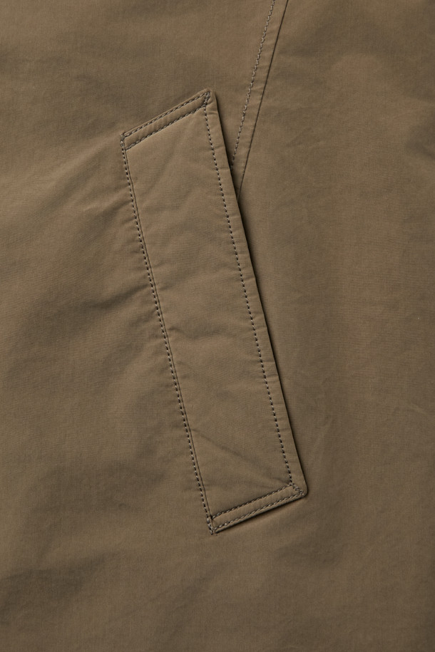 겨울철 일상과 출근룩, 여행룩에 모두 잘 어울리는 구스 코트입니다. 카키와 브라운 두 가지 색상으로 출시되어 미니멀하고 베이직한 스타일을 연출합니다. 롱 기장에 세미 오버핏으로 편안한 착용감을 선사하며, 버튼 여밈 방식으로 간편하게 입고 벗을 수 있습니다. 나일론과 폴리에스테르 혼방 소재로 제작되어 두꺼운 두께감과 부드러운 촉감을 자랑하며, 드롭숄더 디자인과 퀼팅 안감, 생활 방수 및 방풍 기능을 갖춰 보온성을 높였습니다. 
