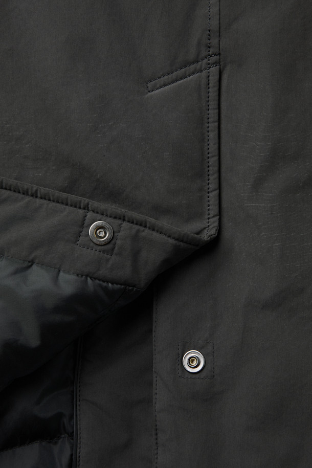 세련된 겨울 스타일을 완성하는 블랙 구스 코트입니다. 일상생활은 물론, 출근룩에도 잘 어울리는 미니멀하고 베이직한 디자인이 특징입니다. 롱 기장에 세미 오버핏으로 편안한 착용감을 선사하며, 지퍼형 여밈으로 간편하게 탈착용할 수 있습니다. 고밀도 나일론과 폴리에스테르 혼방 소재에 구스다운 충전재를 사용하여 뛰어난 보온성을 제공하며, 생활 방수 및 방풍 기능으로 추운 날씨에도 끄떡없습니다. 드롭 숄더 디자인과 퀼팅 안감으로 고급스러운 디테일을 더했습니다.
