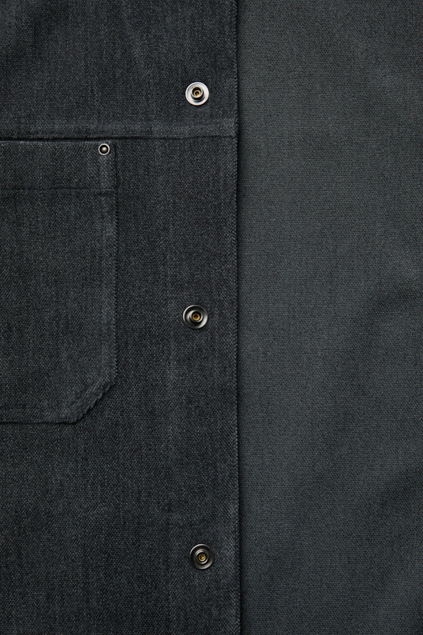 다크 그레이 컬러의 벨루어 아우터 셔츠입니다. 부드러운 셔닐 소재와 폴리에스테르 혼방으로 제작되어, 가을과 겨울에 포근하게 착용할 수 있습니다. 셔츠 칼라와 오버핏 실루엣, 드롭 숄더 디자인으로 미니멀하고 세련된 스타일을 연출합니다. 가슴 요크선, 아웃포켓, 허리 포켓 디테일이 돋보이며, 은은한 광택감과 드레이프성이 특징입니다. 출근룩과 모임룩, 다양한 스타일링에 활용 가능한 아이템입니다.
