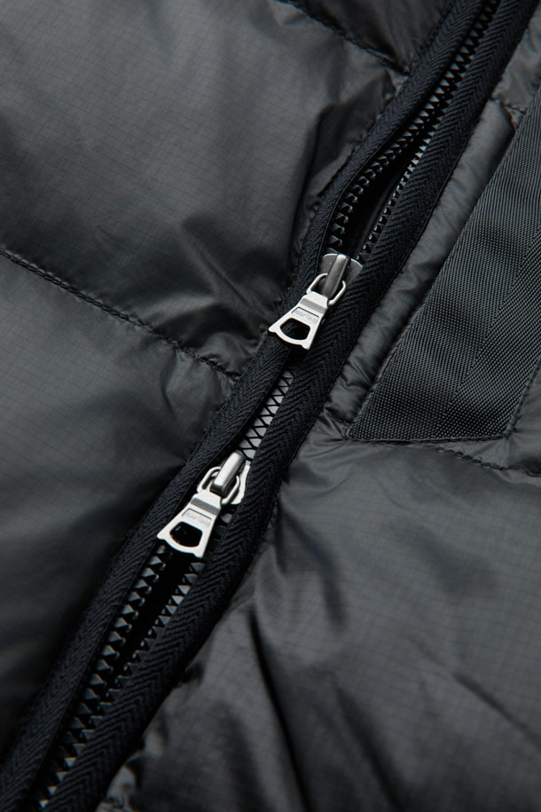 **미들레이어 경량 다운 점퍼**는 가을과 겨울, 일상 및 아웃도어 활동에 적합한 남녀 공용 아우터입니다. 블랙 색상의 무지 디자인으로 미니멀하고 베이직한 스타일을 연출하며, 집업 여밈 방식과 베이직핏으로 편안한 착용감을 선사합니다. 초경량 나일론 소재와 구스다운 충전재를 사용하여 가볍고 따뜻하며, 발수 및 방풍 코팅으로 기능성을 더했습니다. 빌트인 후드 분리가 가능하며, 접밴드 및 절개 보강 설계를 통해 활동성을 높였습니다. 출근룩과 여행룩 등 다양한 TPO에 활용할 수 있는 실용적인 아이템입니다.
