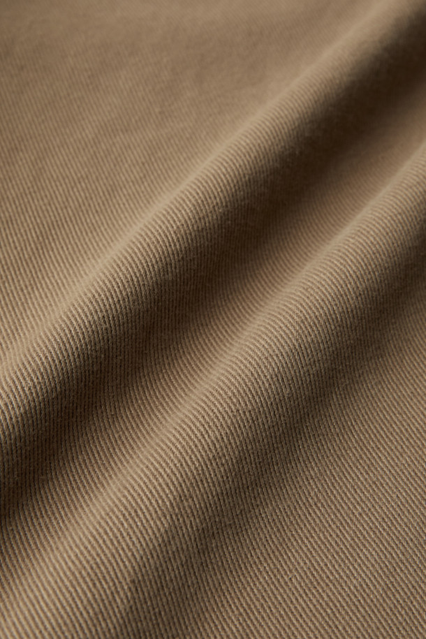 FIVER(파이버) 트윌 배기 팬츠는 캐주얼, 미니멀, 클래식 스타일을 아우르는 바지입니다. 면 소재로 제작되어 탄탄한 촉감을 자랑하며, 봄, 가을에 착용하기 좋습니다. 베이지, 카키 두 가지 색상으로 출시되어 일상 및 캐주얼 룩에 활용하기 좋으며, 출근룩으로도 손색없습니다. 루즈핏의 배기 디자인으로 편안함을 더하고, 원턱 디테일과 허리 스트링, 웨이스트 밴딩으로 활동성을 높였습니다. 힙 포켓과 사이드 포켓, 버튼/지퍼 여밈으로 실용성을 강조한 제품입니다.
