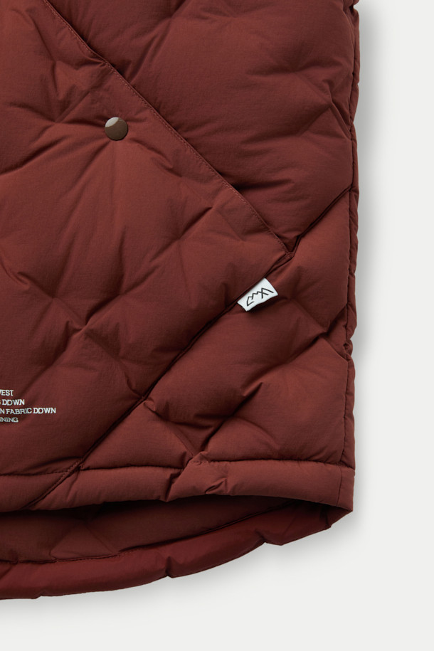 CMF 우븐 다운 베스트는 가을, 겨울철 일상 및 아웃도어 활동에 적합한 남녀 공용 베스트입니다. 브라운 컬러의 퀼팅 패턴과 크롭 기장으로 캐주얼, 스포티, 미니멀 스타일을 연출할 수 있습니다. CMF WOVEN 기술을 적용하여 다운팩 없이 X자 구조로 직조되었으며, 다운 90%, 페더 10% (700FP)의 안감과 다운 본딩 처리로 보온성을 높였습니다. 얇고 가벼운 나일론, 폴리우레탄 소재에 넉넉한 두께감과 부드러운 촉감, 사선 포켓 디자인이 특징입니다. 캠핑룩으로 활용하기 좋으며 스냅 여밈 방식으로 편안하게 착용할 수 있습니다.
